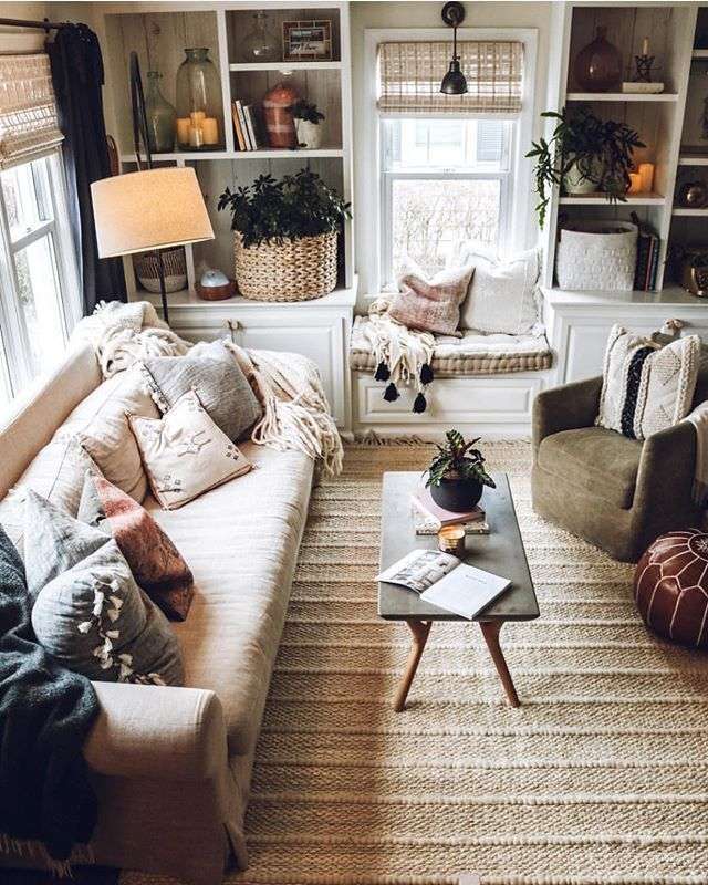 A woven rug extends between a pale sofa and a green chair, beneath a narrow coffee table.