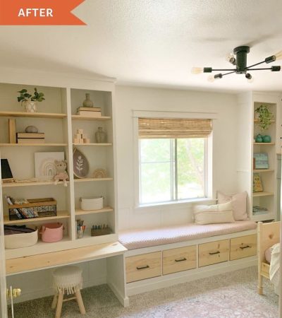 A window seat above storage drawers, with open shelves and a built-in desk alongside.